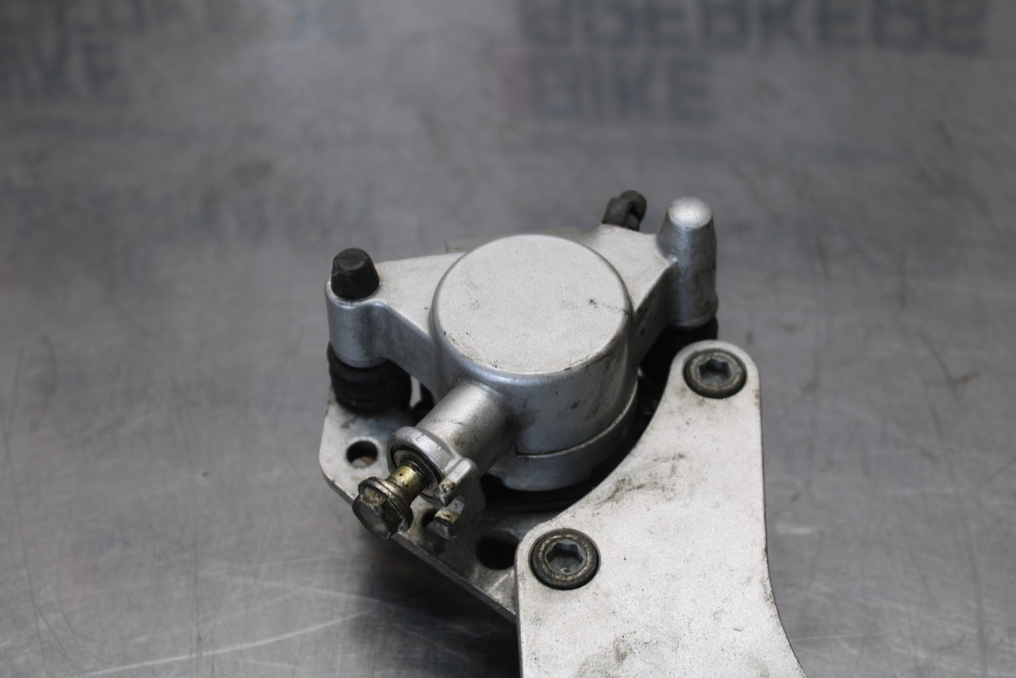 03-08 KAWASAKI VULCAN 1600 REAR BACK BRAKE CALIPER W MOUNT BRACKET BB196