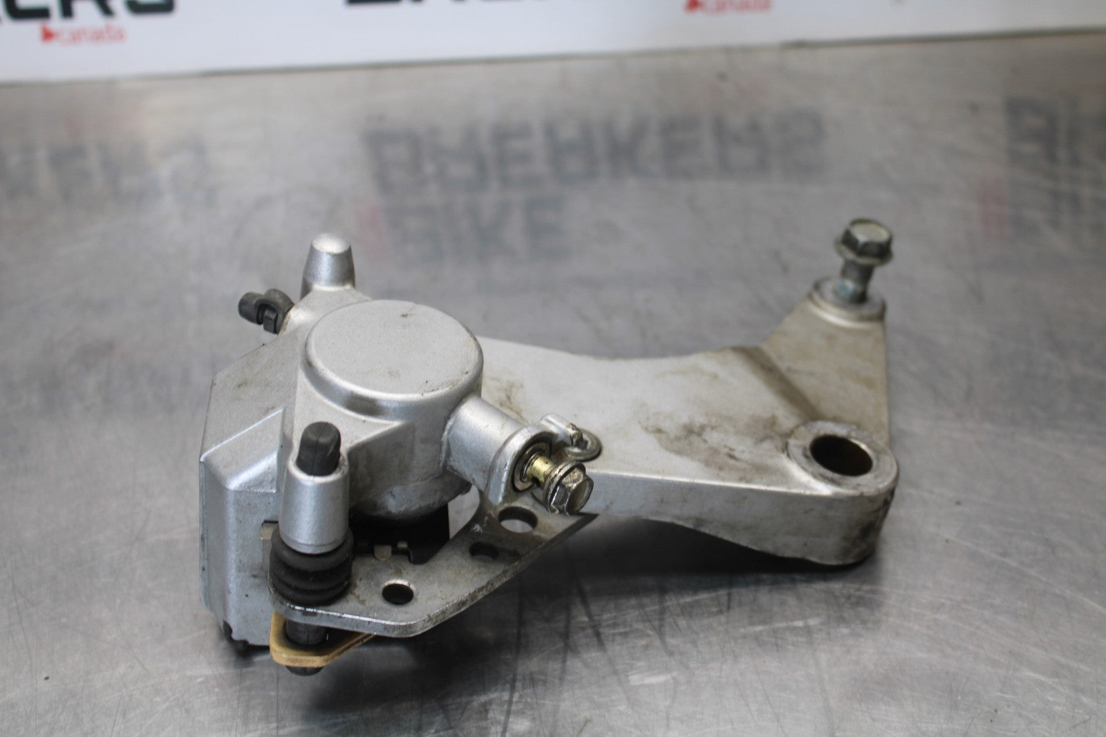 03-08 KAWASAKI VULCAN 1600 REAR BACK BRAKE CALIPER W MOUNT BRACKET BB196